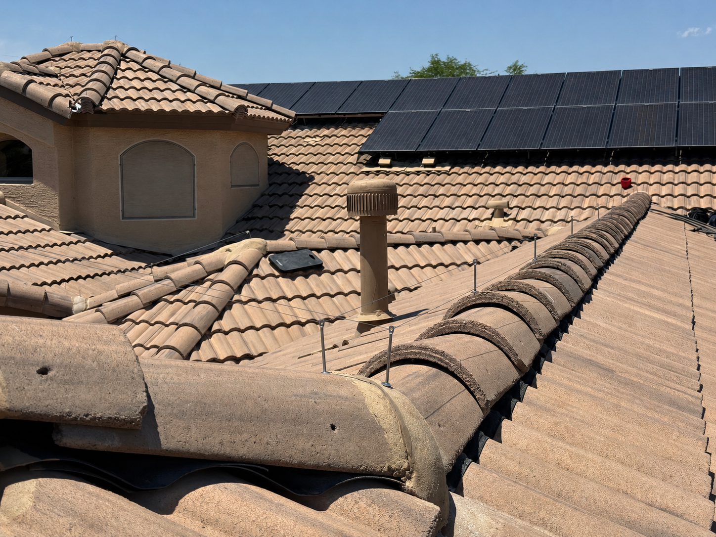 Ridgeline wire installed near solar panels on a tile roof