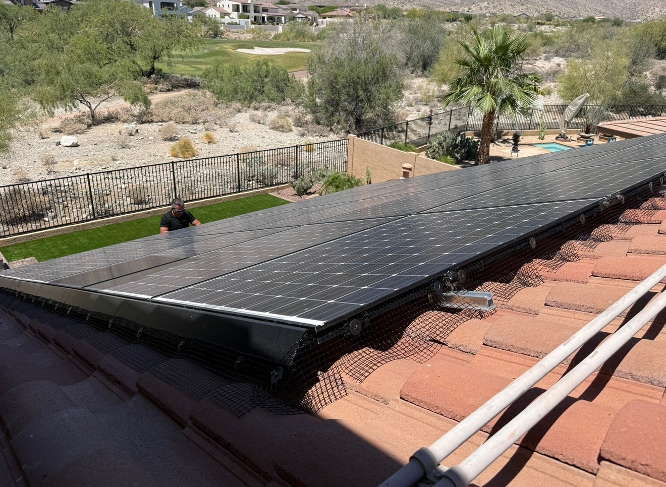 Solar panel mesh installed around panels on a desert tile roof